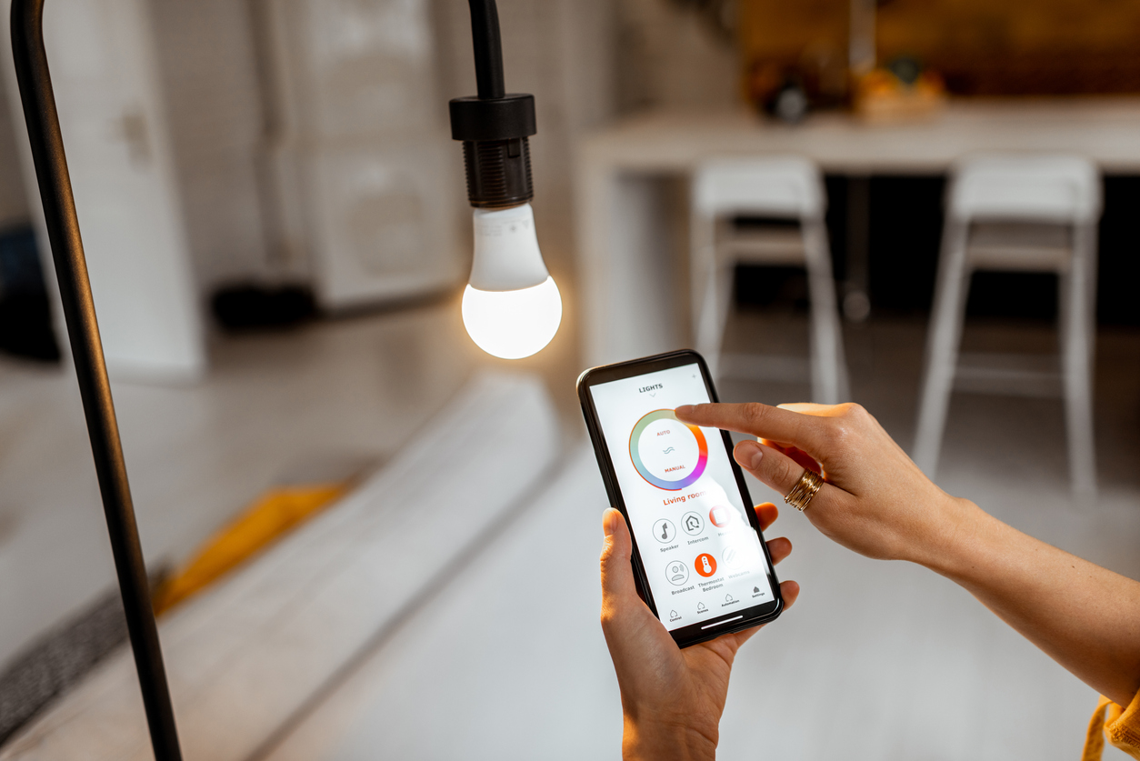 The 11 Biggest Mistakes You Can Make With Your Smart Home woman using smart phone to control lighting system