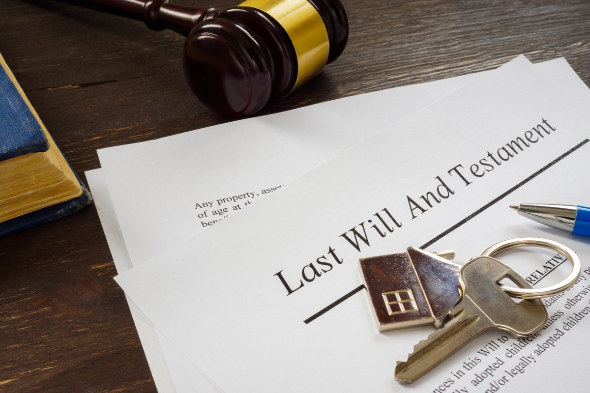 iStock-1313323878 inheriting a house last will and testament document with house keychain