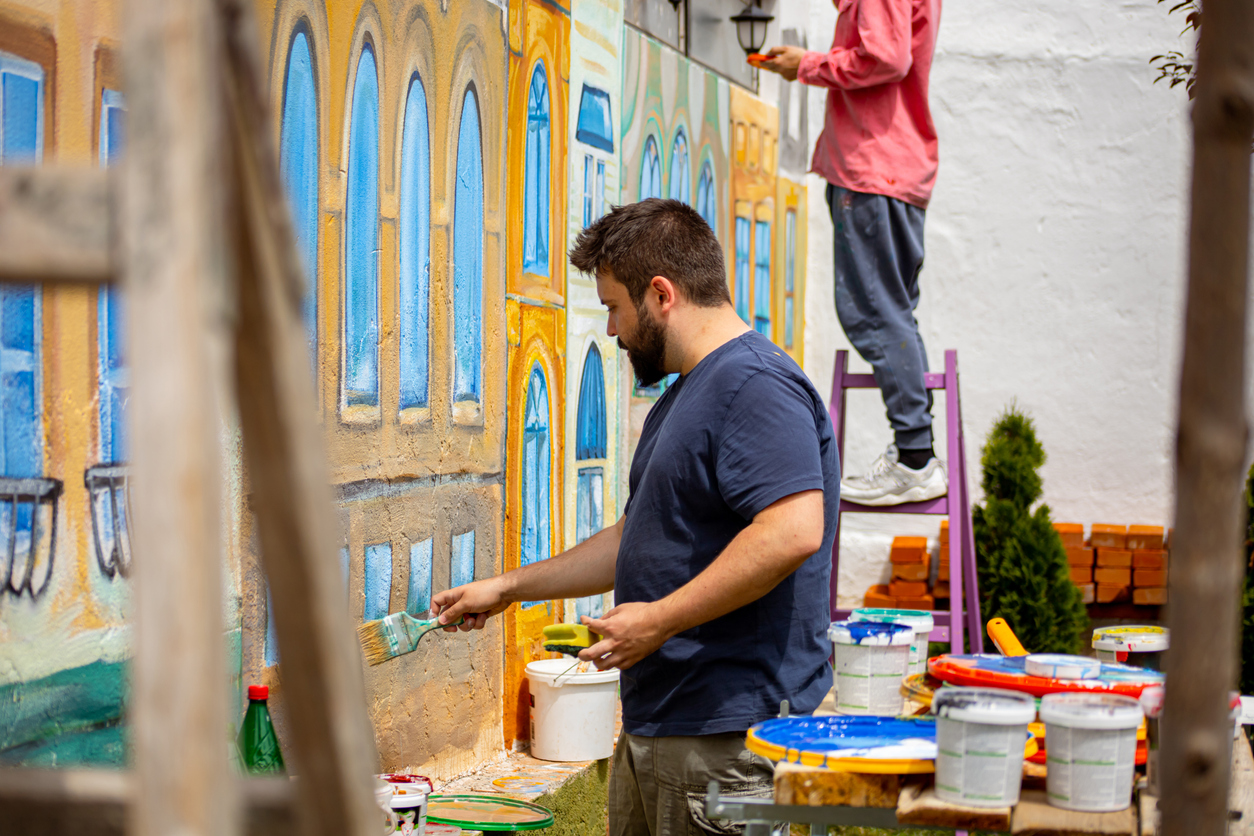 iStock-1320995298 volunteer opportunities two artists painting a mural on an outdoor wall