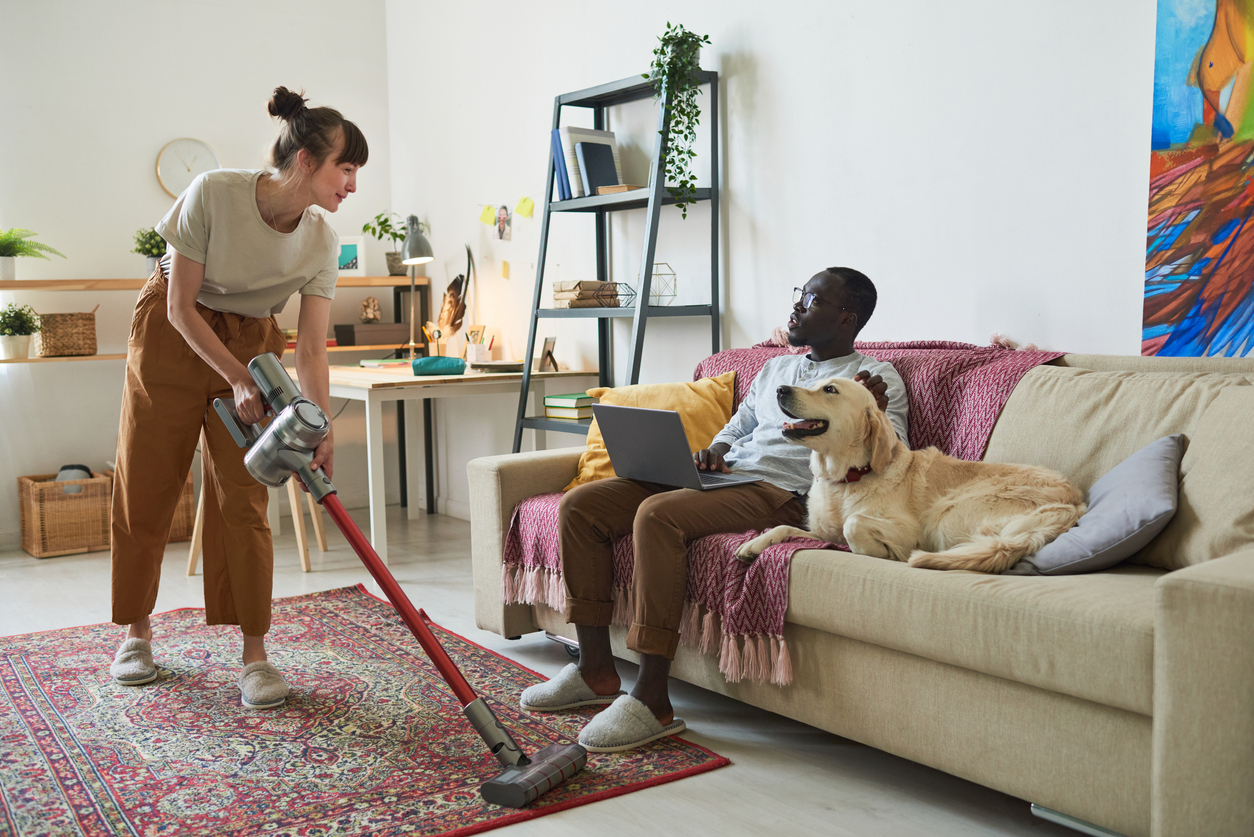 iStock-1322268799 procrastination hacks woman vacuuming while friend watches