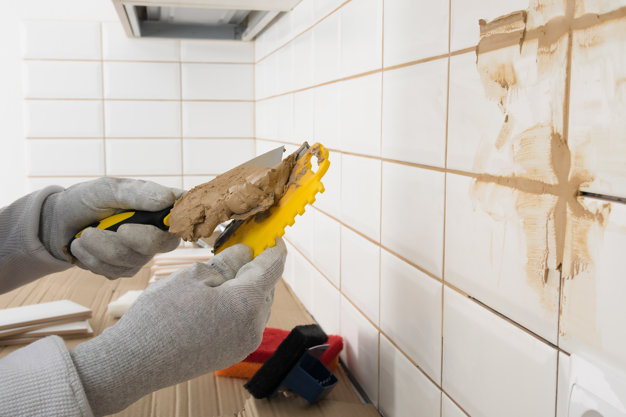 iStock-1328166055 how long does grout take to dry applying brown grout to spatula