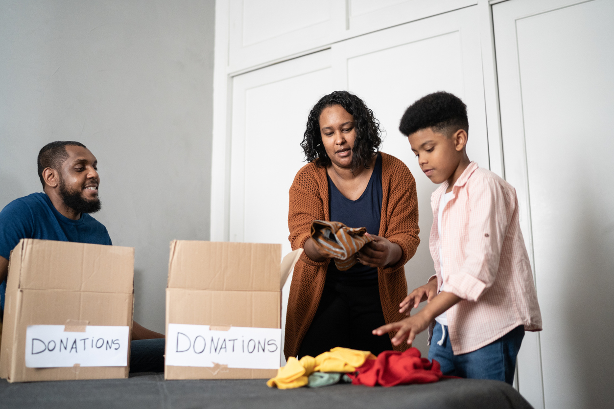 iStock-1336548533 ways to improve your life family putting clothes into donation boxes