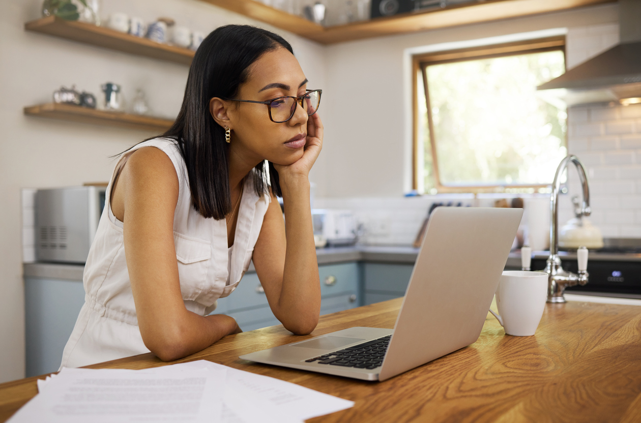 The 11 Biggest Mistakes You Can Make With Your Smart Home woman frustrated with poor internet connection staring at laptop working in kitchen