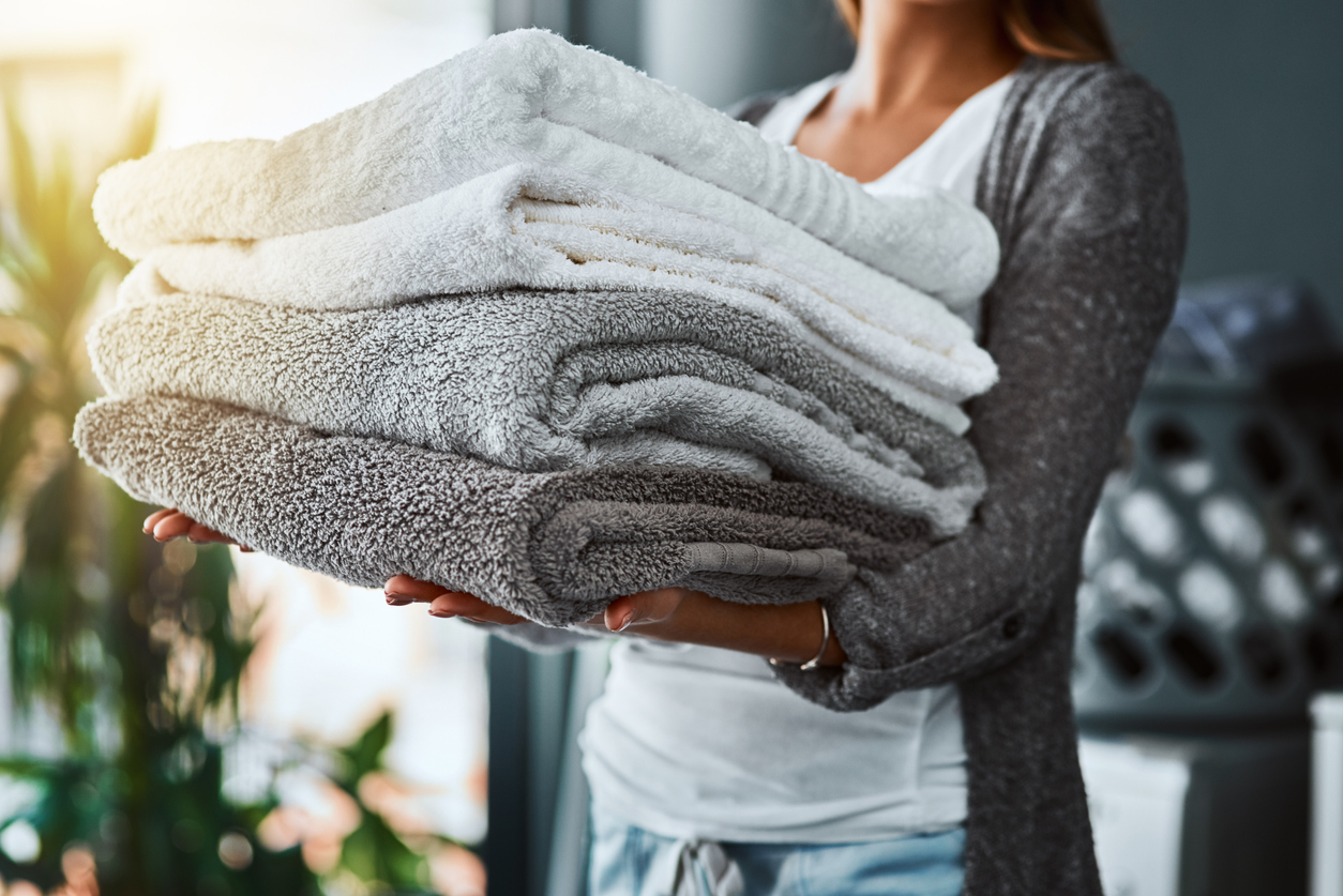 how to use oxiclean woman holding folded clean towels