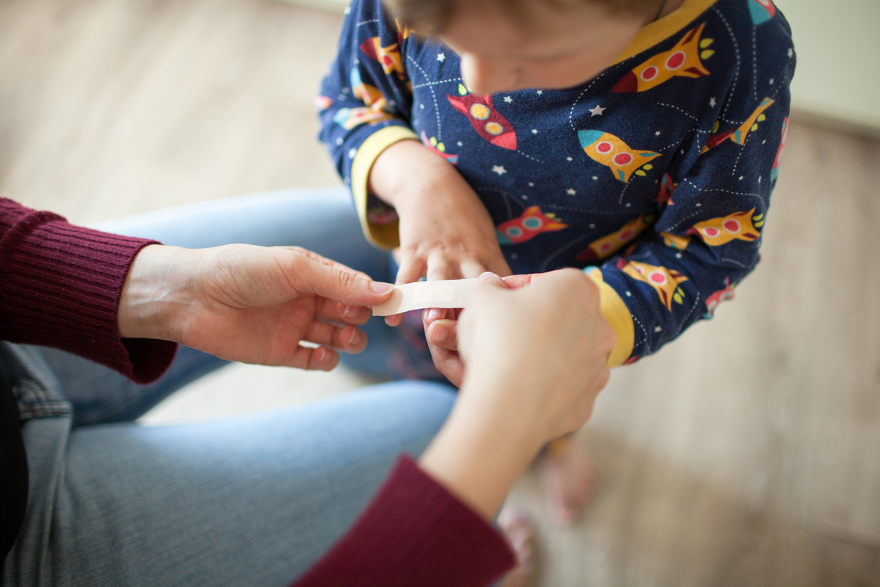 coconut oil uses woman putting bandaid on small boy wearing pajamas