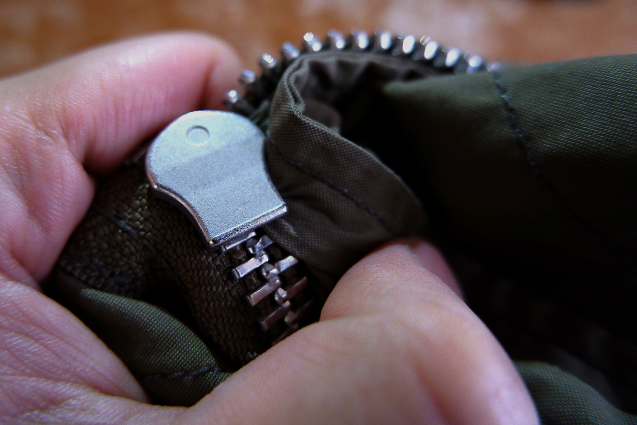 coconut oil uses close up fingers holding zipper stuck in fabric