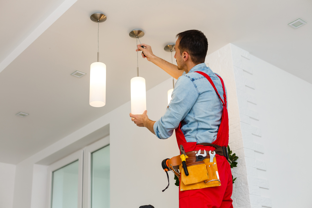 iStock-1263134450 tax returns home improvements Electrician man worker installing ceiling lamp