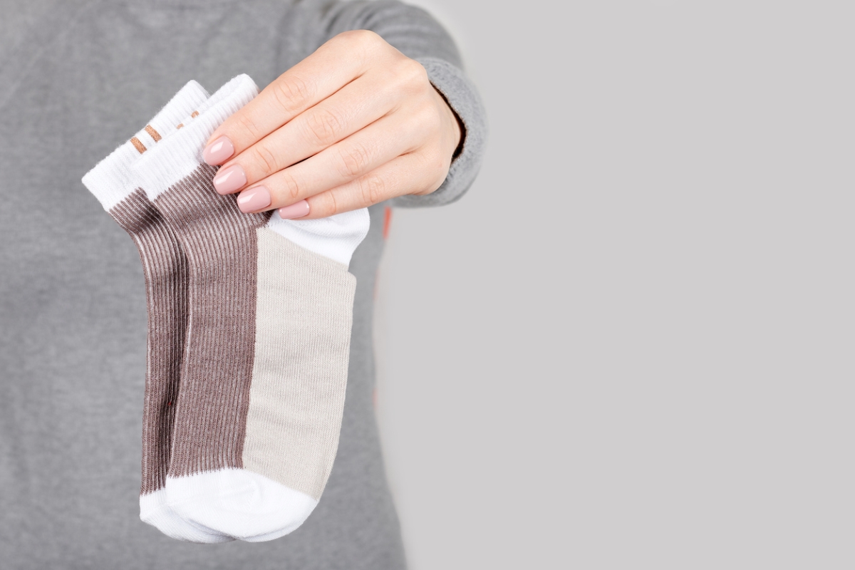 ways to clean behind and under every appliance - woman holding pair of socks
