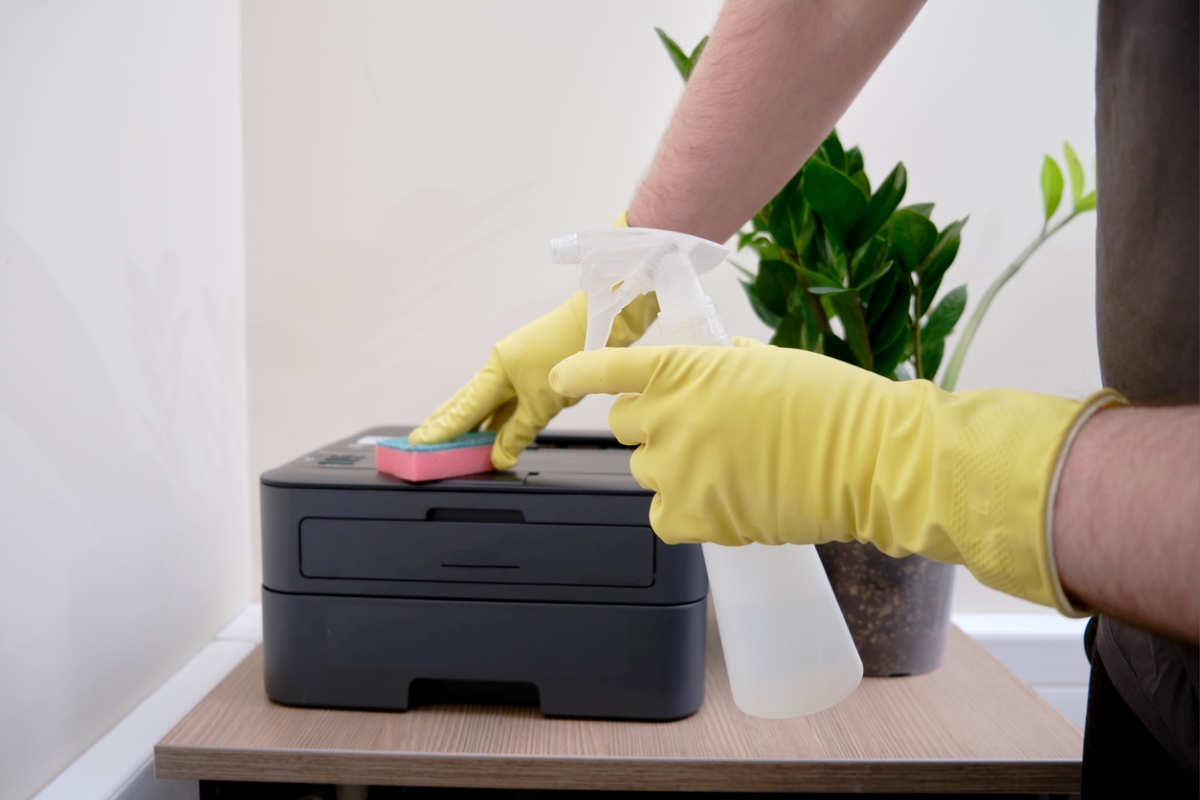 electronics you never clean - yellow gloved hands wiping home printer