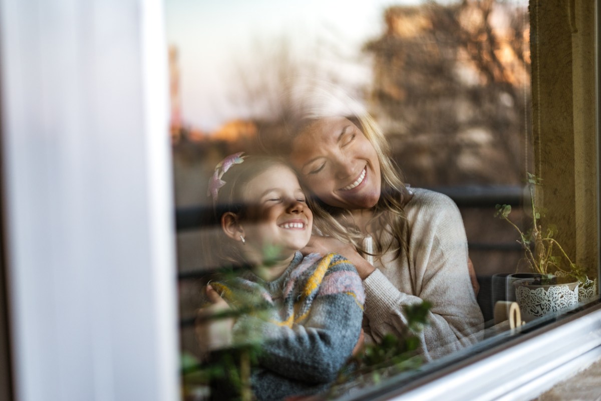 security window film mother and daughter through window smiling safe