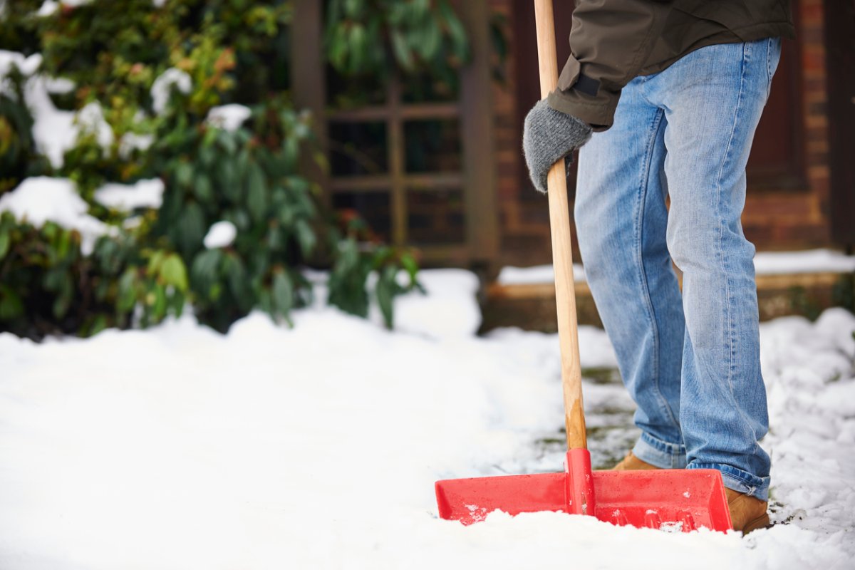 coconut oil uses man shoveling snow on sidewalk near house