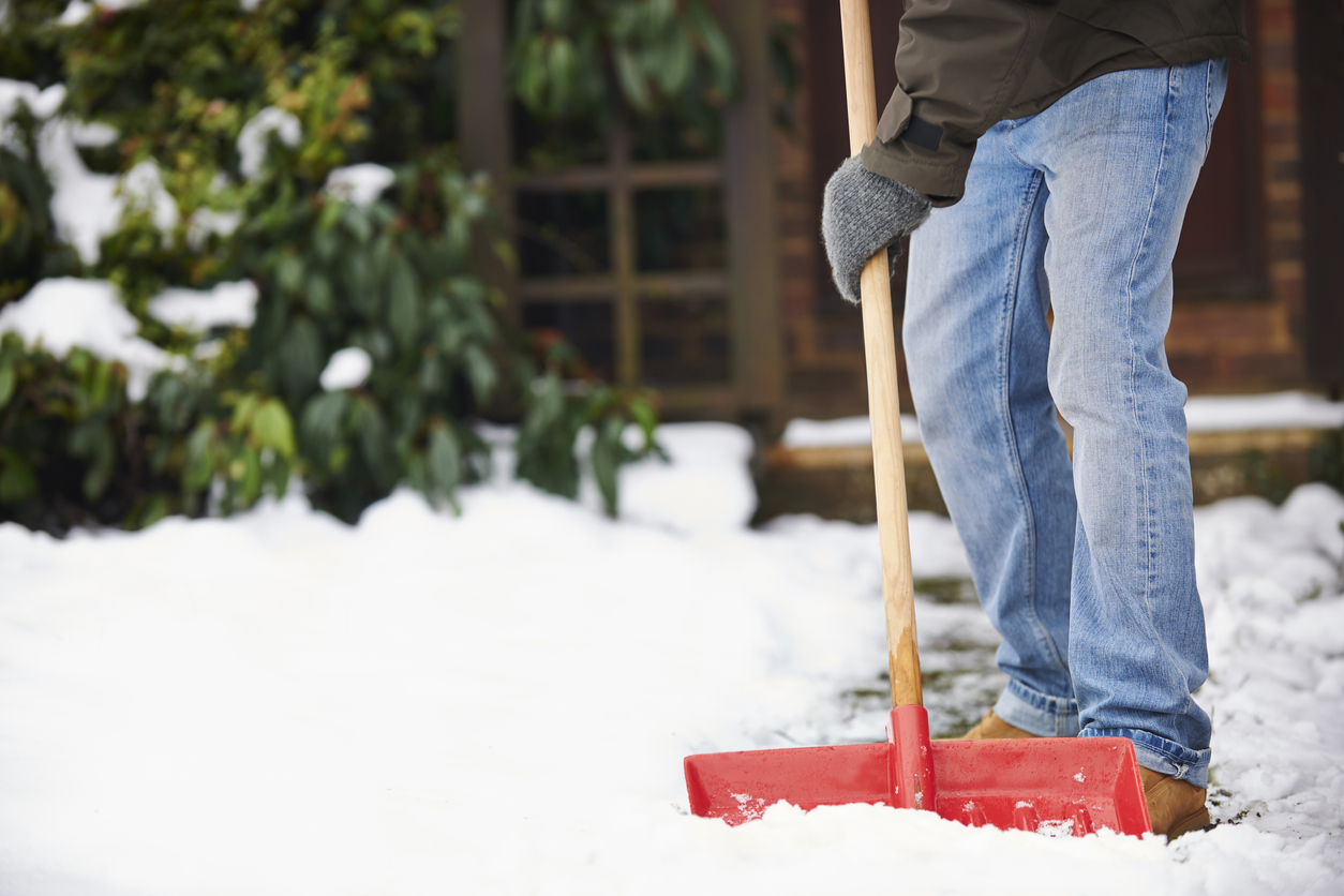 coconut oil uses man shoveling snow on sidewalk near house