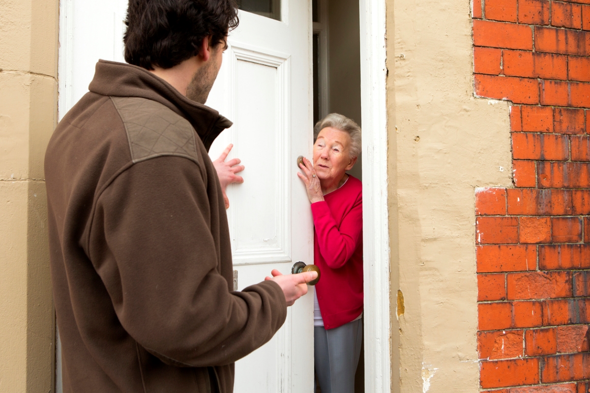 home title theft - older woman answering door