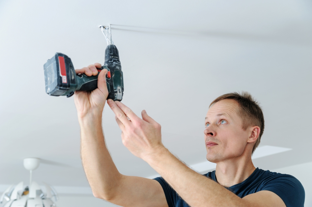 most dangerous power tools - man drilling ceiling with cordless drill