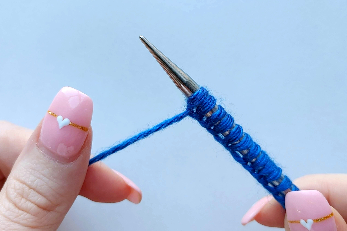 Hands demonstrating how to cast on when knitting