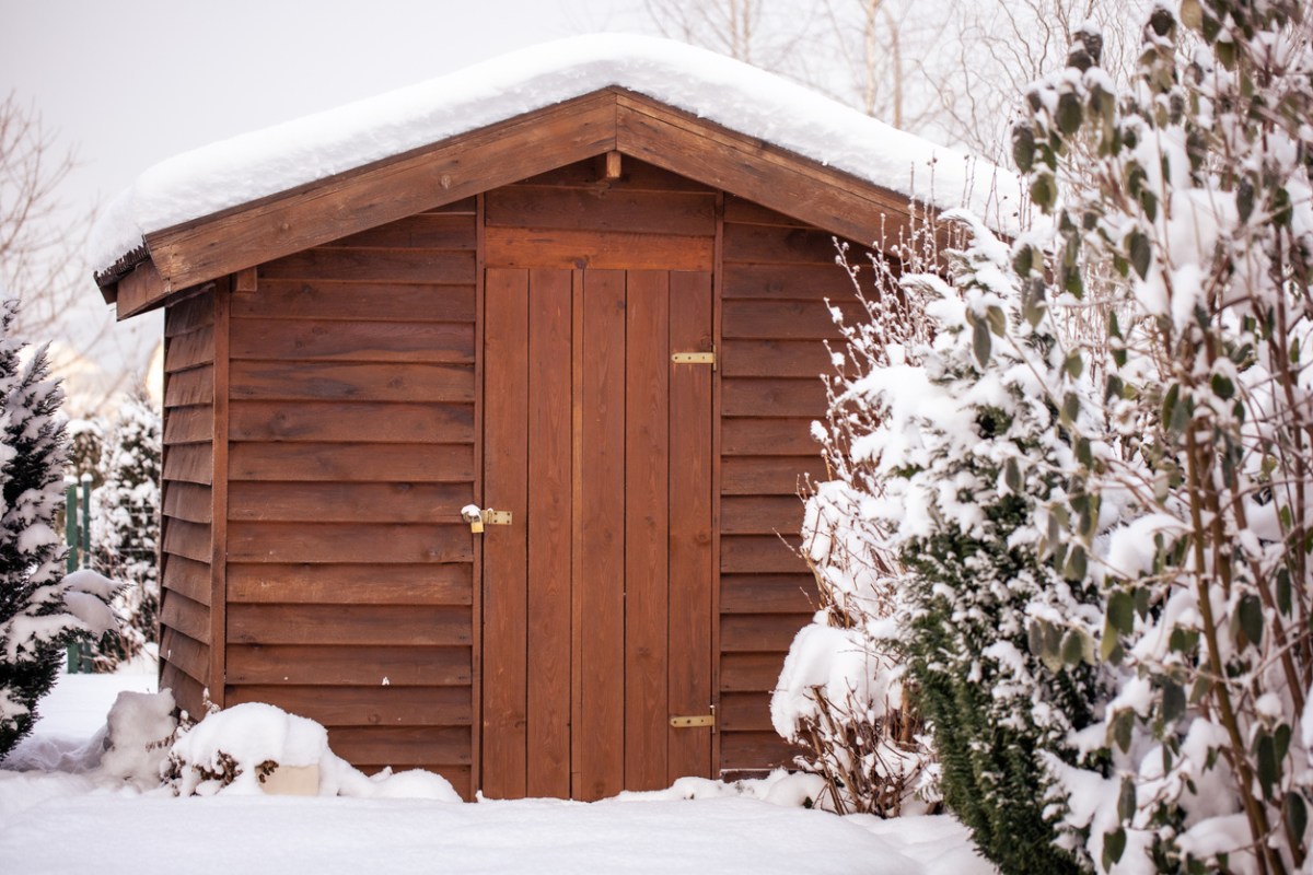 Wooden insulated shed topped with a snow-topped roof