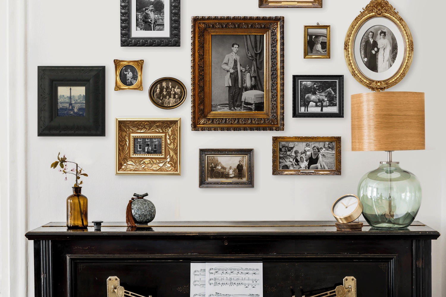Gallery wall of old family photos over a black piano