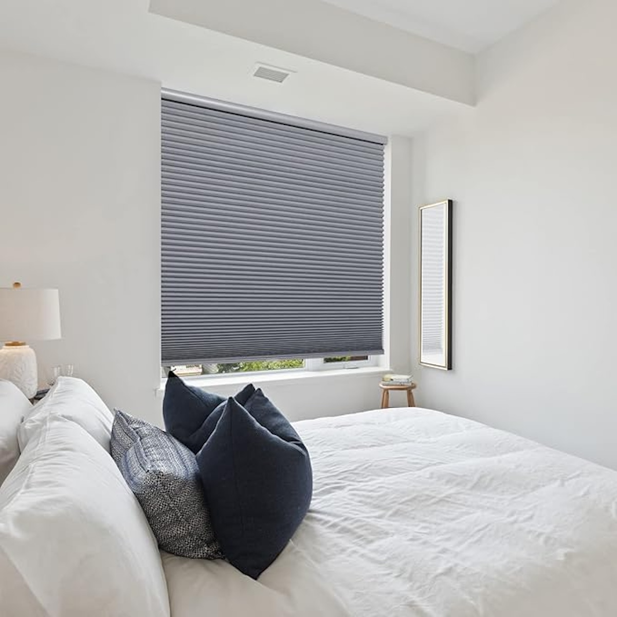 A bright, white bedroom with grey blackout curtains. 