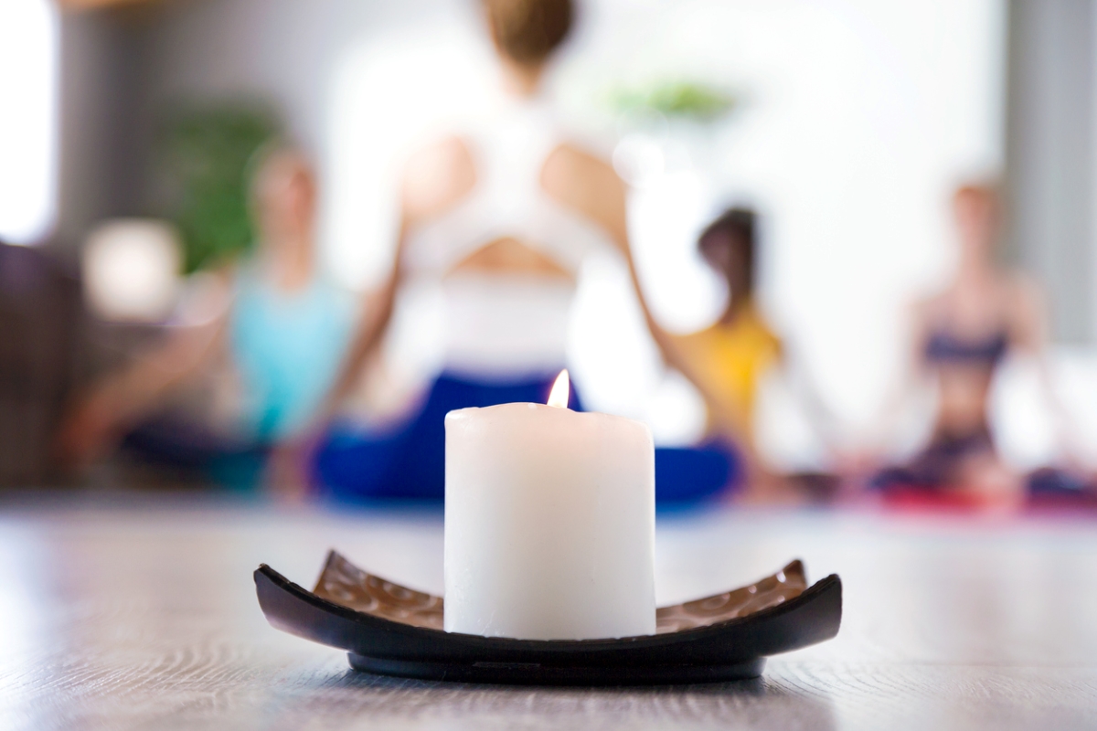 decor with candles - single candle with blurred yogis