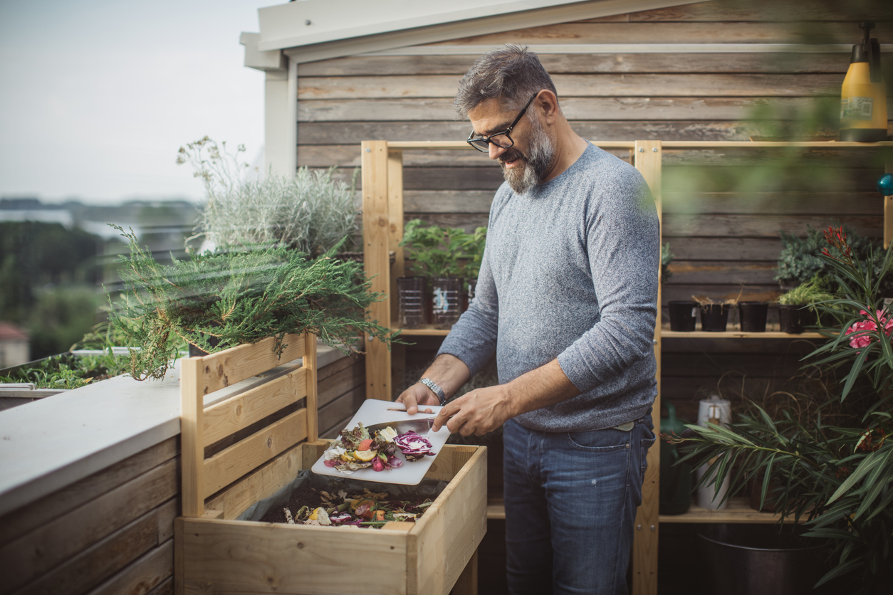 iStock-1160204160 organic gardening tips man making compost out of leftovers