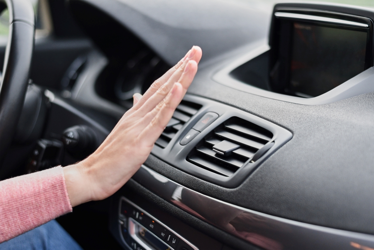 car maintenance tasks -hand in front of car air conditioner