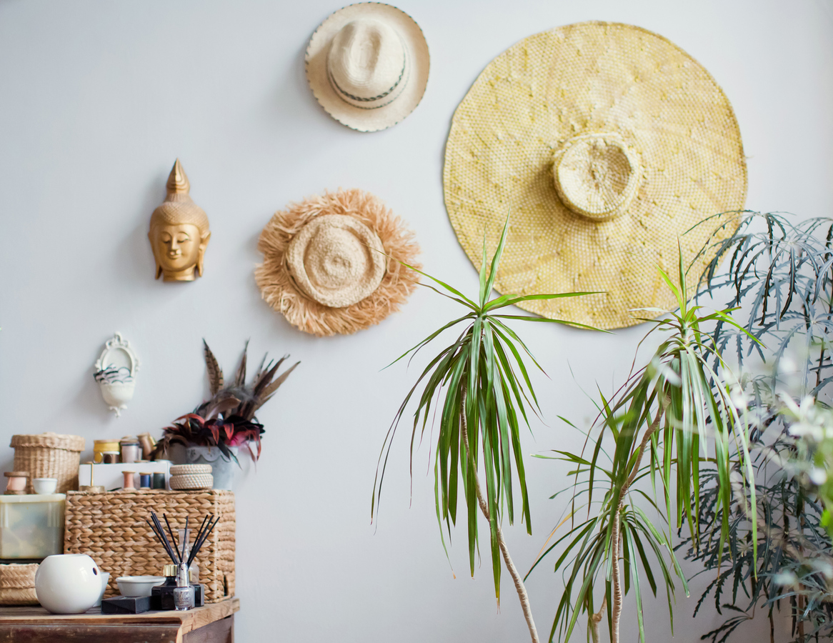 iStock-1302252845 wall decor ideas Hanging straw hats on white wall