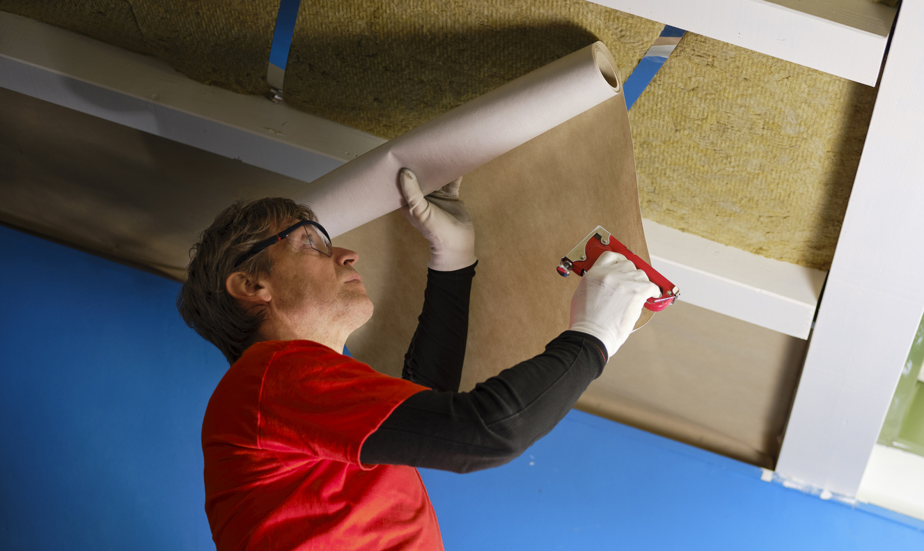 iStock-1383042185 how to insulate a shed worker installs vapor barrier