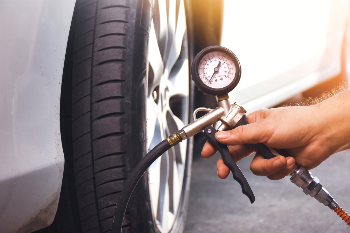 car maintenance tasks - hand holding tire pressure