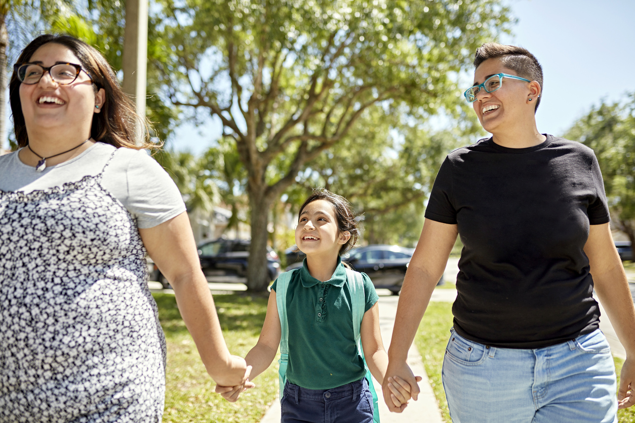 iStock-1411828603 master planned community Smiling LGBTQIA family walking to school