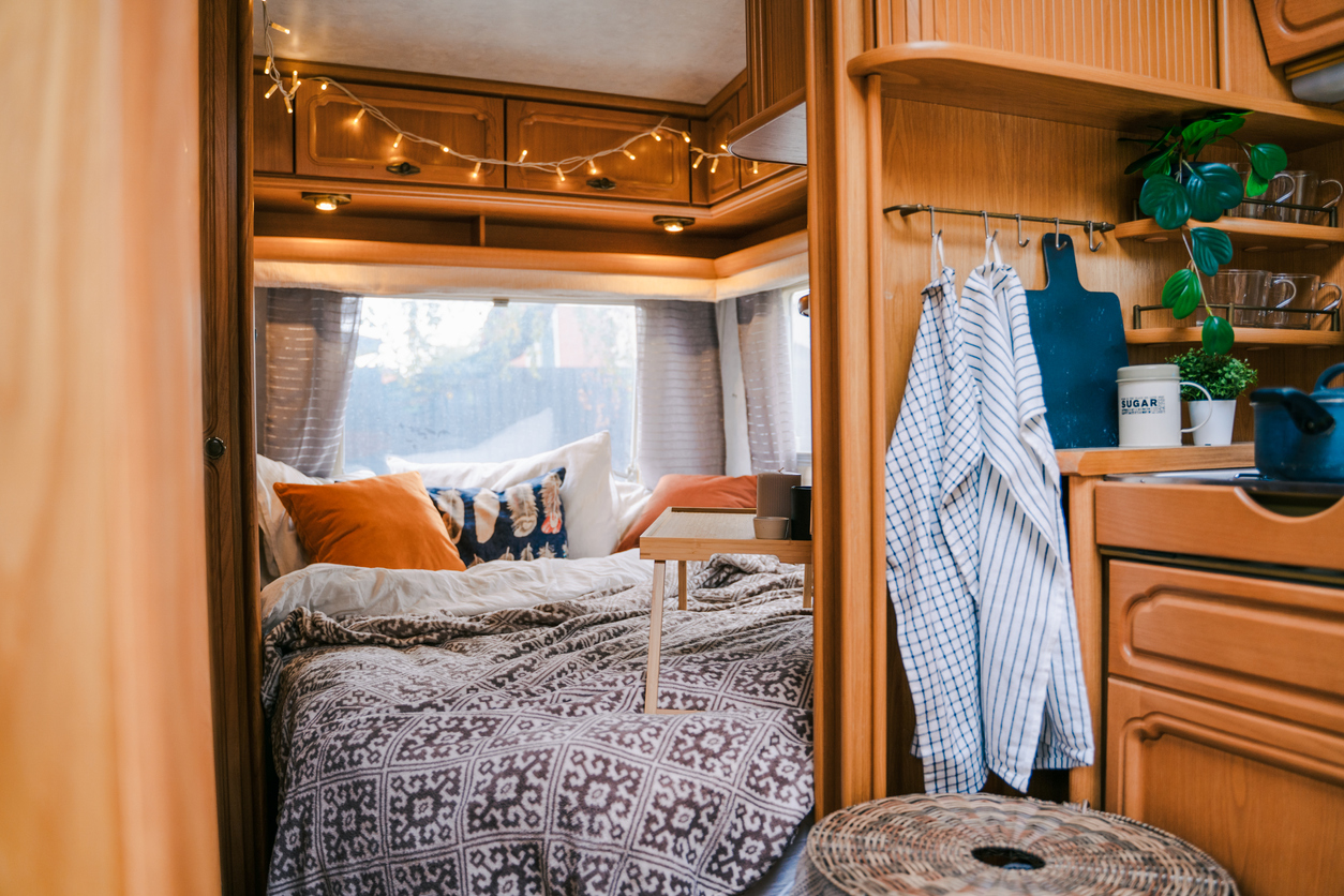 iStock-1413621524 camper decor bed in small camper with nice bedspread and pillows