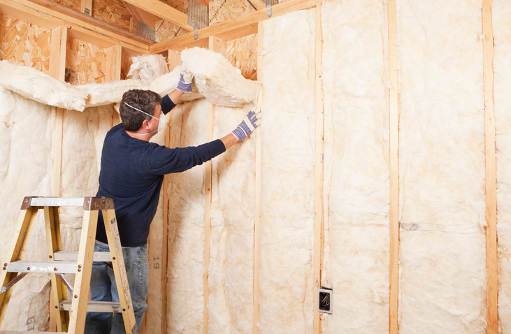 energy-efficient-tax-credit-man-installs-insulation-between-wall-studs