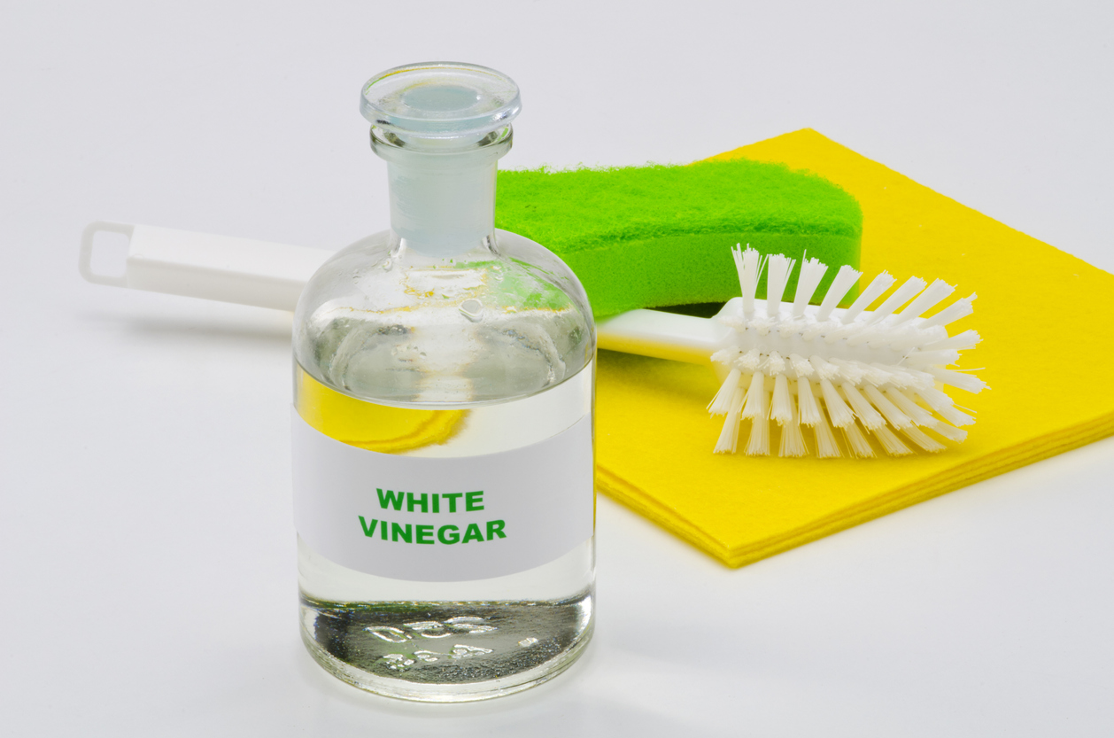 iStock-468621537 best types of vinegar for cleaning white vinegar with cleaning supplies in background