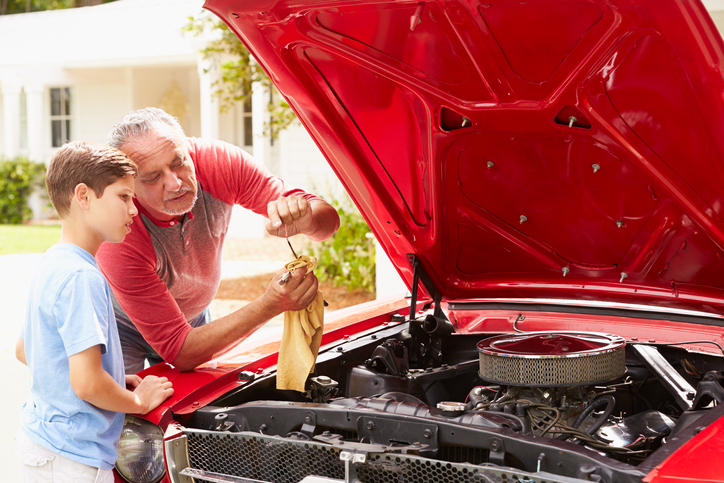 spring-car-maintenance-grandpa-shows-grandson-how-to-check-oil-in-car-engine