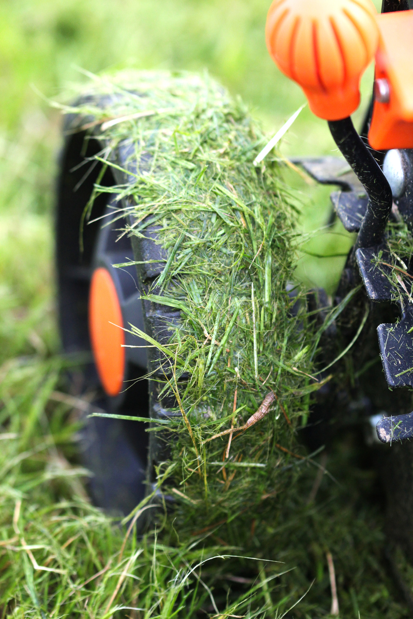 mowing mistakes everyone makes lawn mower wheel covered in wet grass