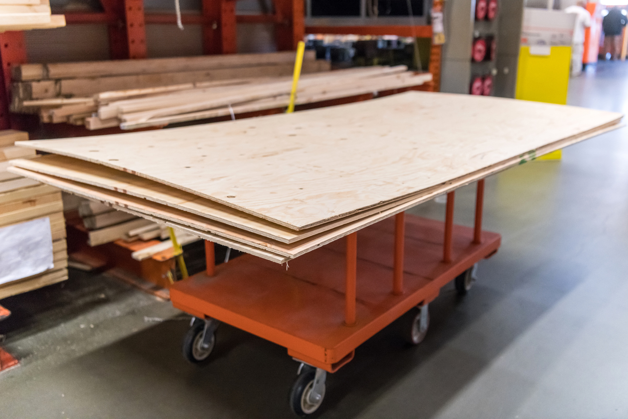 iStock-923027568 14 Wise Ways to Weatherproof Your Garden Plywood on a cart in a home goods store