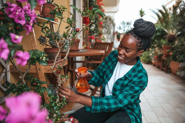 istock patio_plants_woman watering plants on balcony.