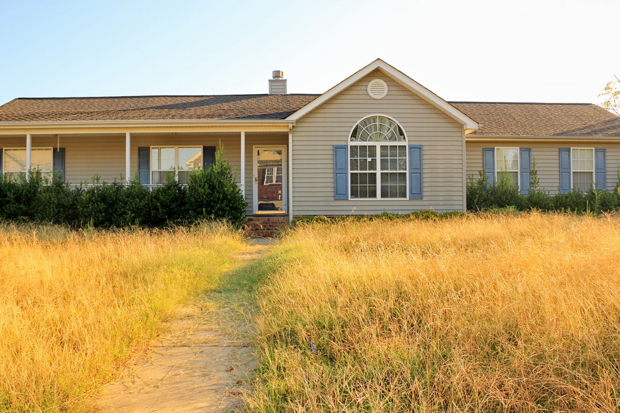 ranch style house with unkempt yard dry yellow overgrown lawn