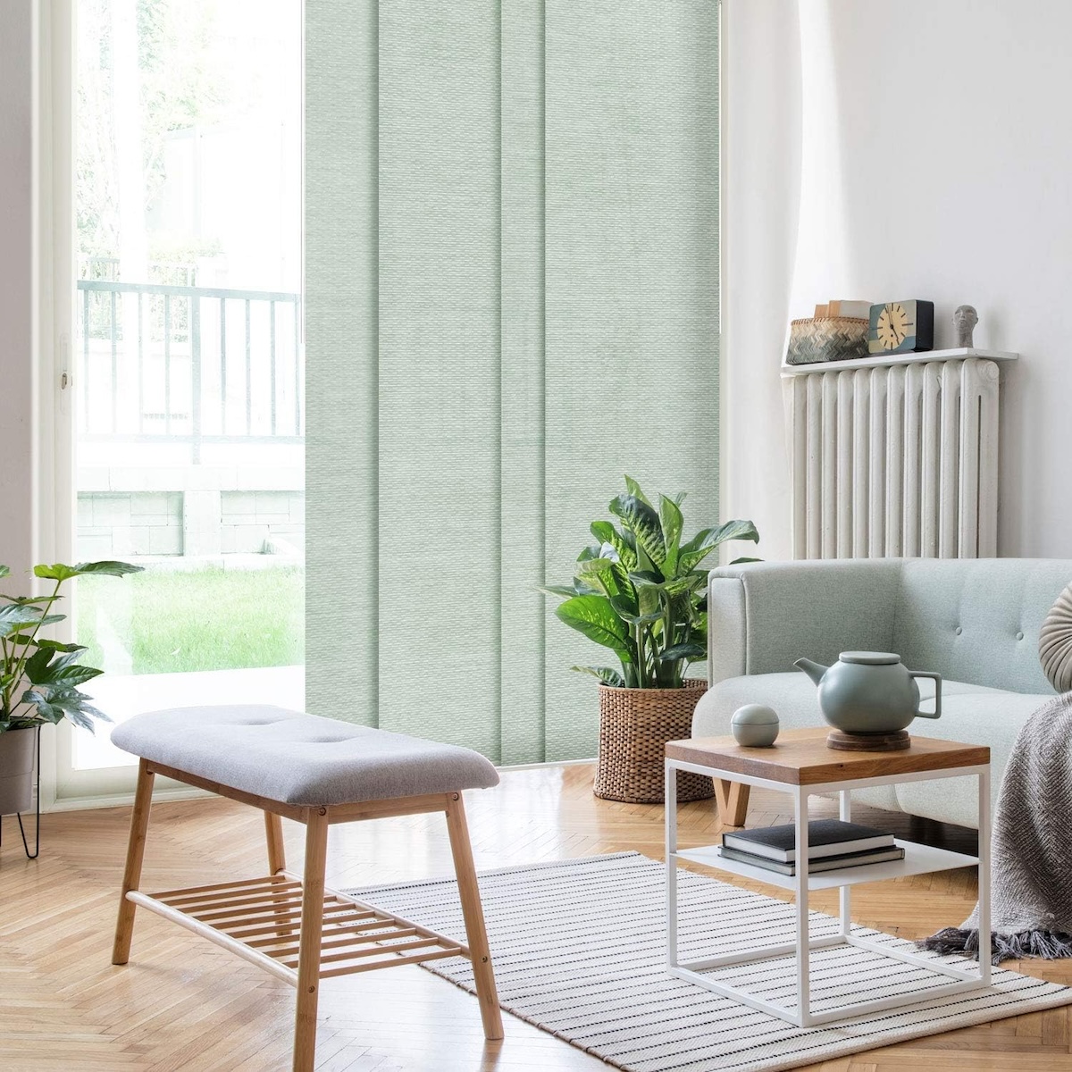 Mint green panel blinds hang on large windows in a bright, modern living room. 