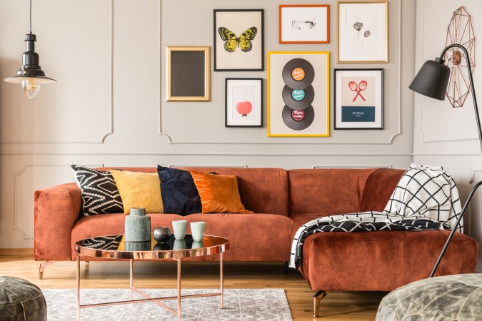 modern living room with orange sofa and colorful gallery wall prints
