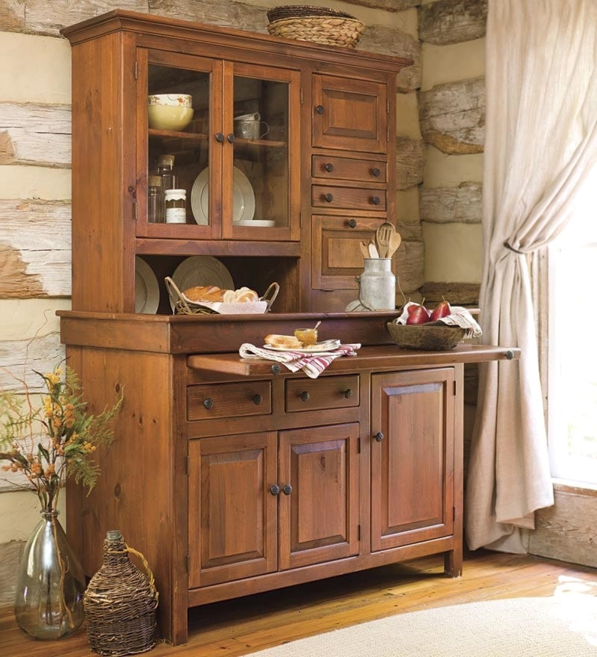 Wooden hoosier cabinet with dishes of food on counter