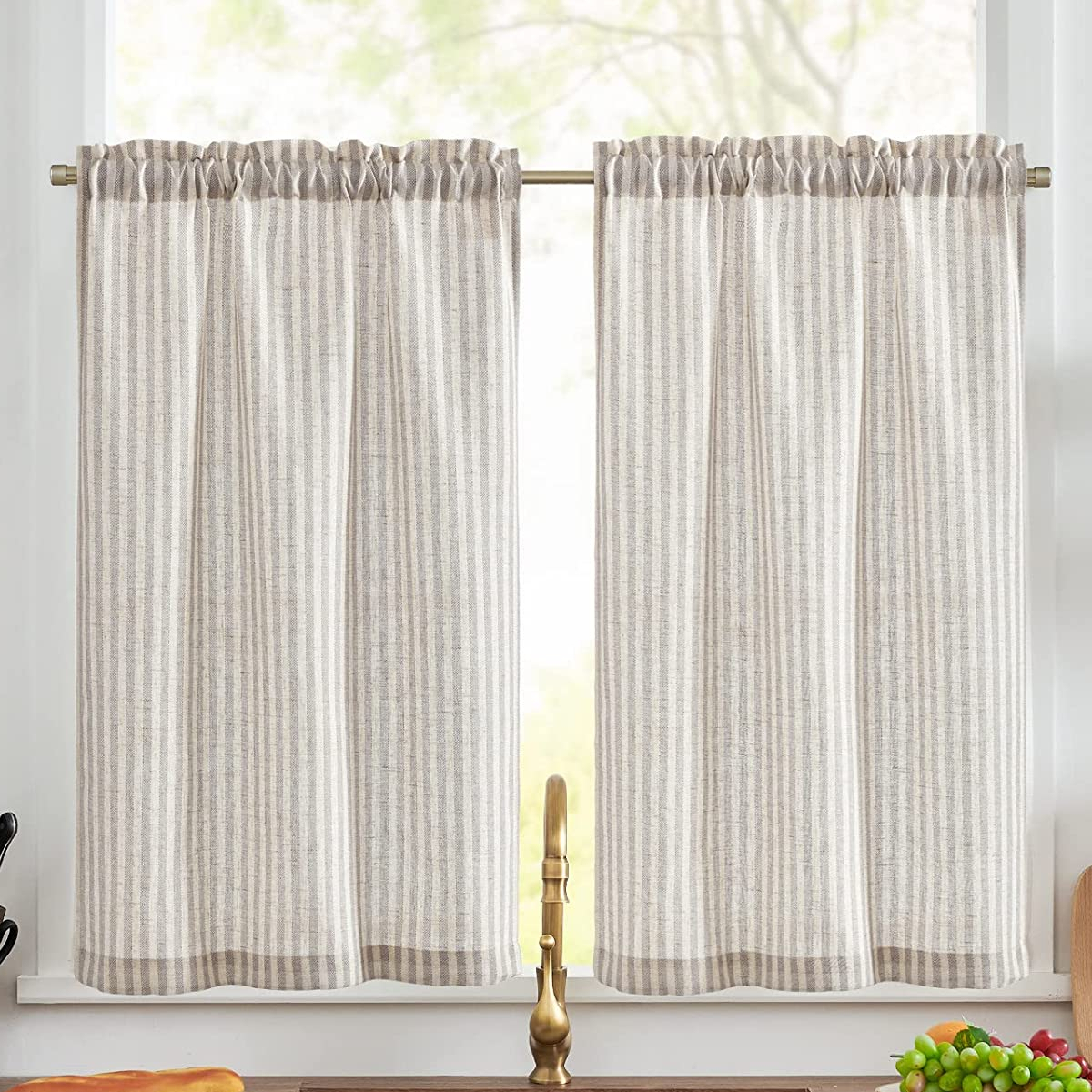 White striped cafe curtains hanging over a kitchen window