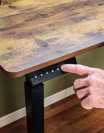 Close-up of a man's hand using digital controls to raise the Fezibo standing desk