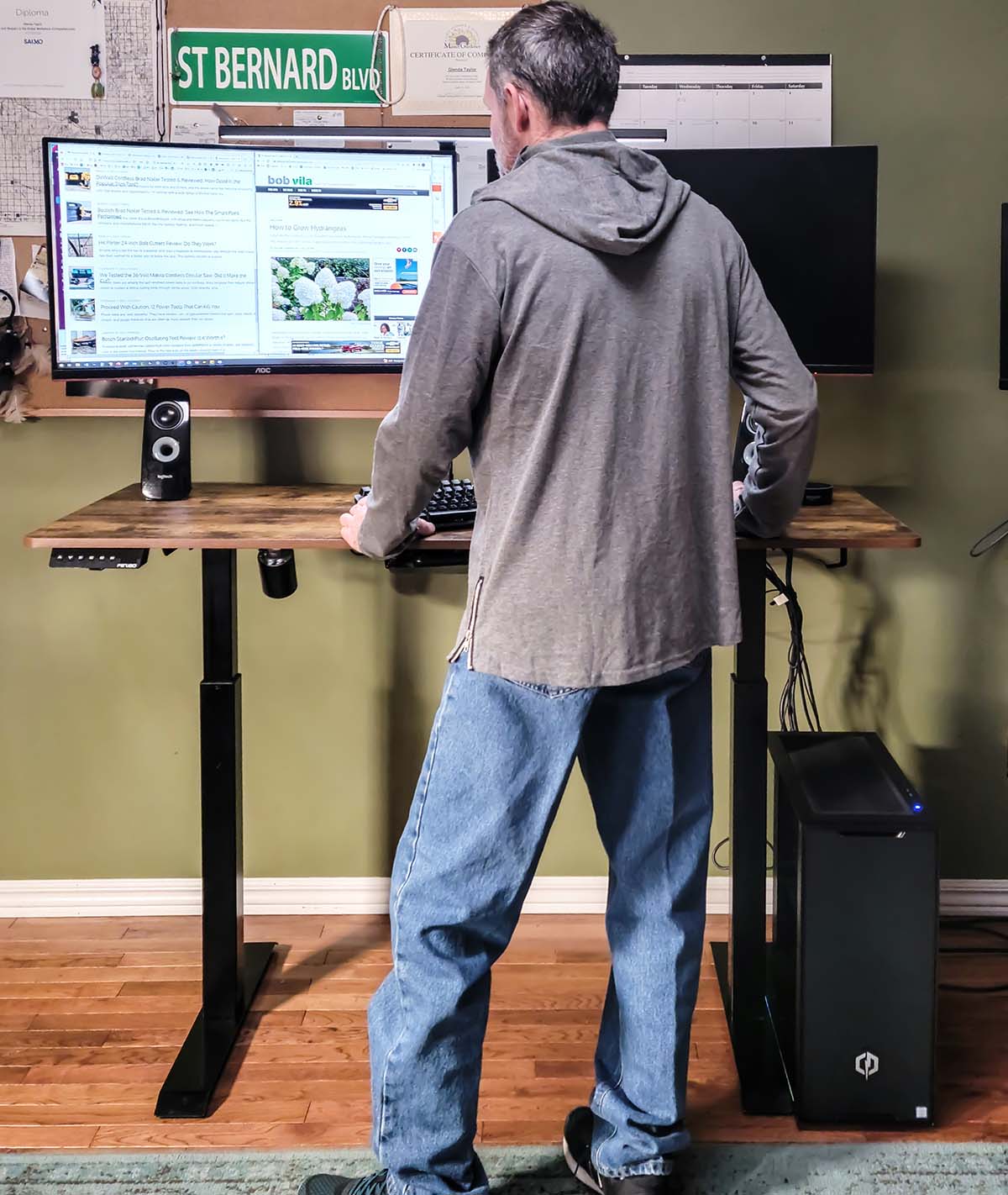 A man stands and works on a computer at the Fezibo standing desk
