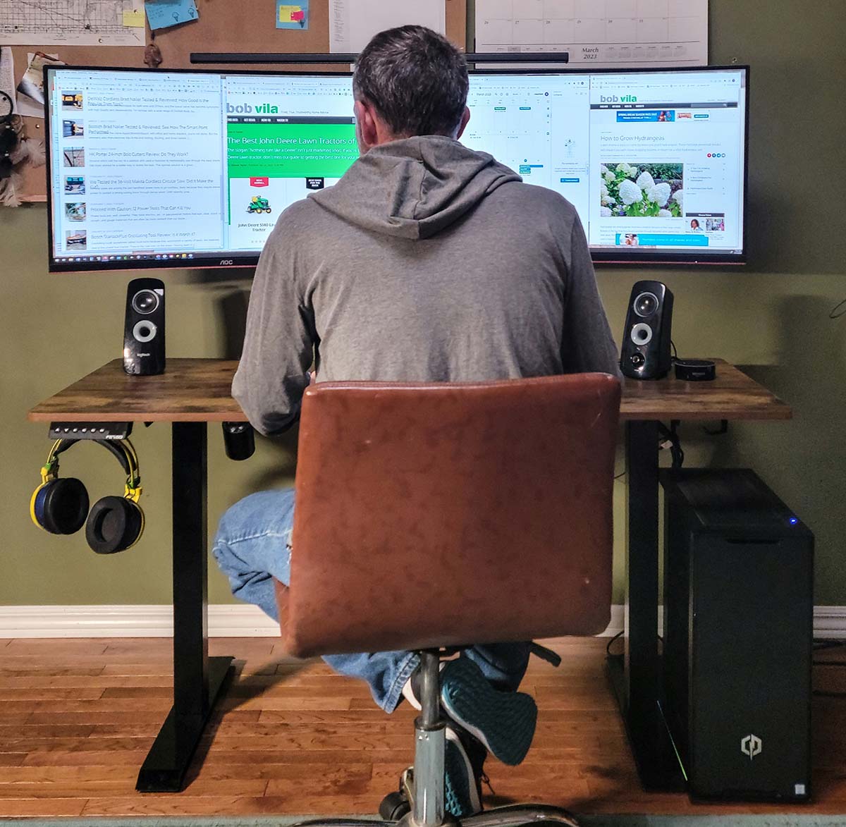 A man sits and works on a computer at the Fezibo standing desk