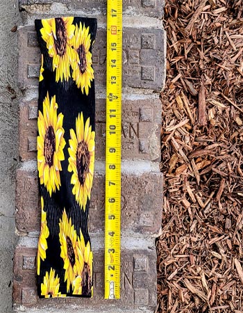 Wellday gardening sleeves next to a tape measure showing a length of 16.5 inches