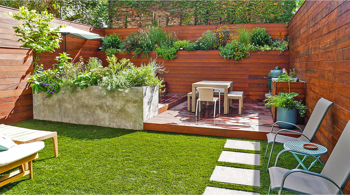 outdoor deck with large wood wall featuring tall deep planters with lush plants