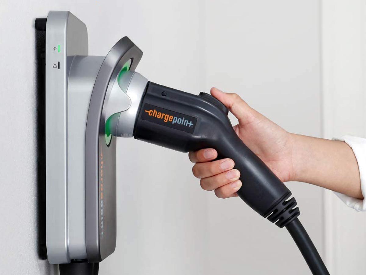 A person removing the best home EV charger option from its charger