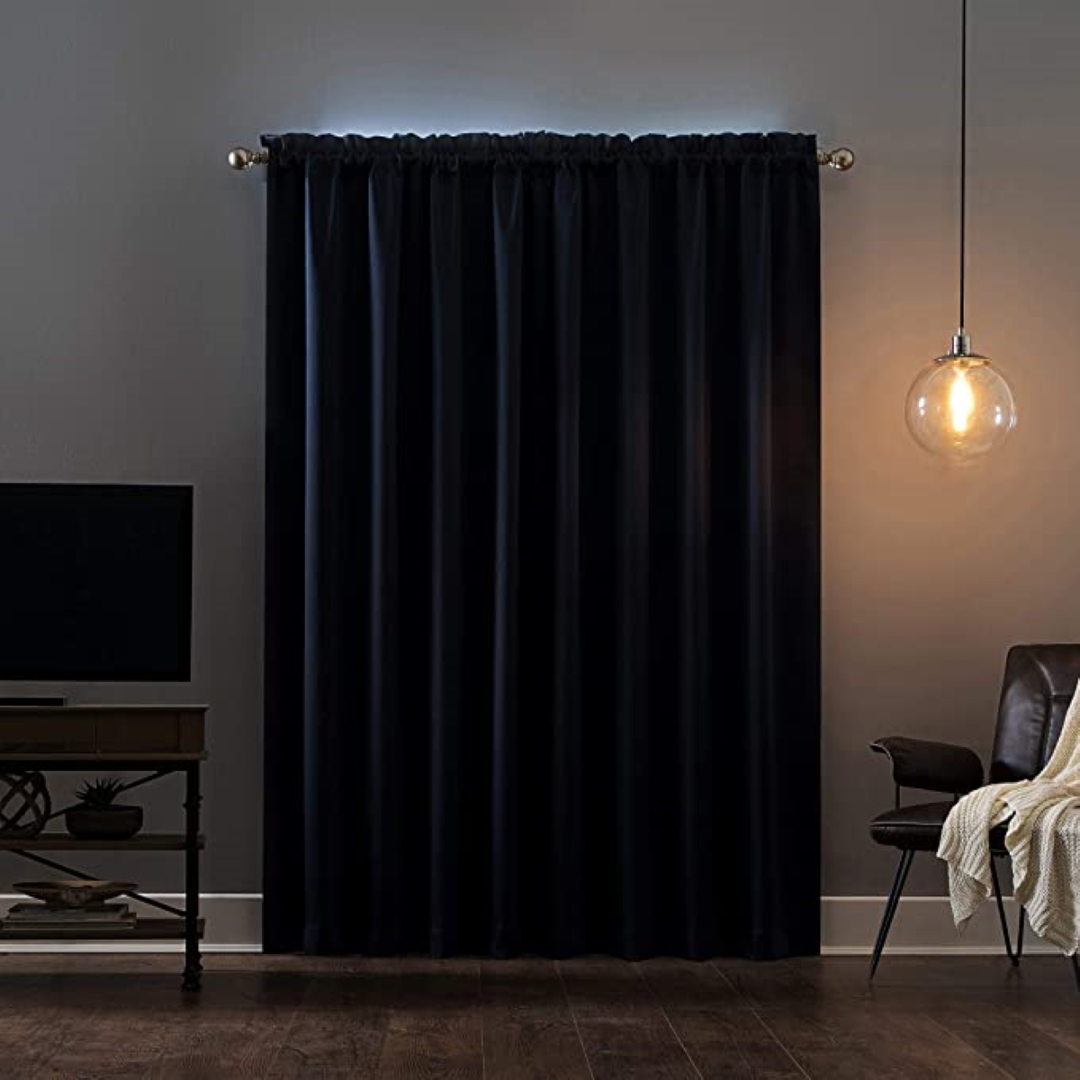 Dark blackout curtains covering window in dim living room