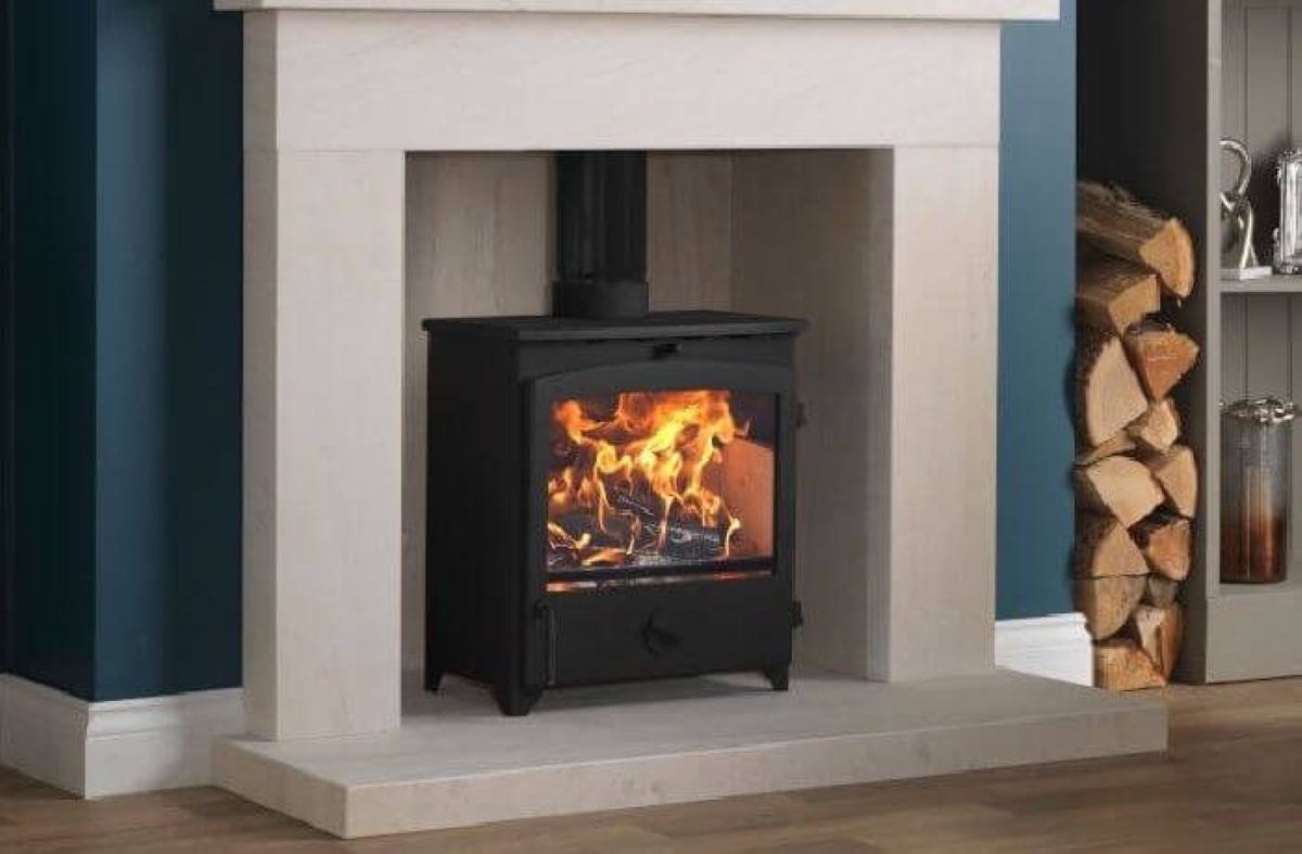 Wood stove in modern stone fireplace with wooden logs