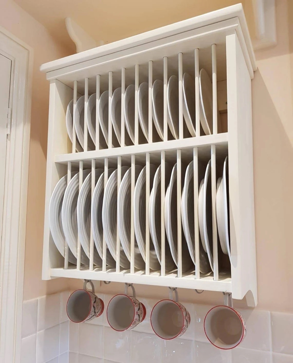 White plate rack with dishes and cups hanging below